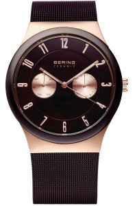 Men's watch by Bering, with high-tech sapphire crystal,  brown dial with rose gold subdials and numbers, date  and day of the week indicators, high-tech brown ceramic bezel, and brown mesh band. Water-resistant to 5 ATM.