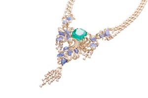 A peacock-inspired emerald and tanzanite necklace by Farah Khan set with a 51-carat Colombian emerald surrounded by carved tanzanites  in 18-karat yellow gold and diamonds.