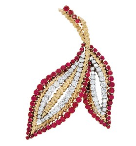 A claw-set diamond, ruby, and 18-karat gold leaf brooch by Van Cleef & Arpels.