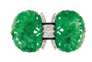 Platinum and 18-karat gold art deco brooch with jadeite plaques carved as a pair of butterflies amongst flowers, centring a diamond-set arch accented by black enamel.