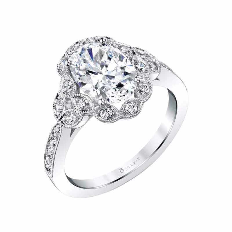 14-karat white gold engagement ring (0.29 ctw) with floral halo and milgrain beaded petals surrounding one-carat oval centre by Sylvie Collection. MSRP $2385