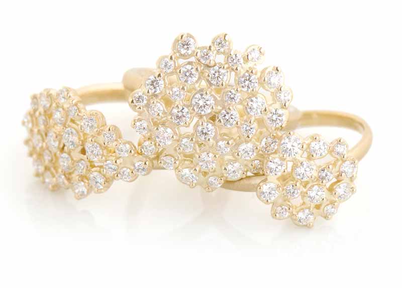 Handmade gold ‘Festival’ rings by Anne Sportun with clusters of round brilliant-cut diamonds.