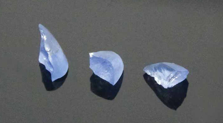 Broken fragments of a cabochon stress-tested by a hammer create triangular fragments with cracks radiating toward the centre of the stone. Photos courtesy GRS Laboratories