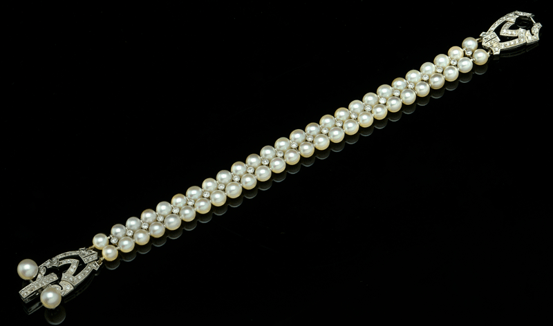 The art deco-style piece (circa 1925) features a double row of cultured pearls, bordering a millegrain-set line of circular-cut diamonds. 