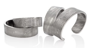 Unisex Damascus steel cuffs with hand-forged designs by Chris Ploof Designs.  MSRP US$950