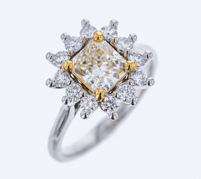 18-karat white and yellow gold ring by RDI Diamonds, featuring a 1.04-carat radiant diamond centre stone with a burst halo.