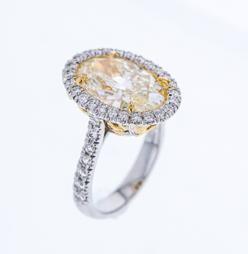 18-karat white and yellow gold ring by RDI Diamonds with an oval 5.04-carat yellow diamond centre stone.