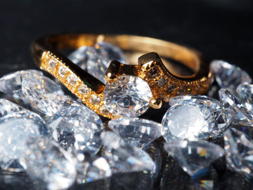 A diamond ring resting on a pile of diamonds.