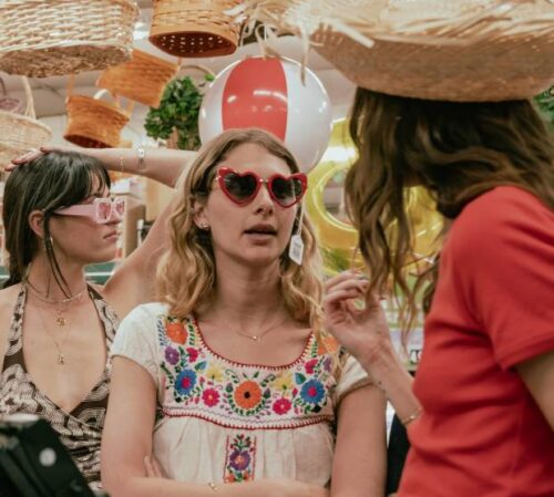 Three girls stand in store wearing Mejuri jewellery.